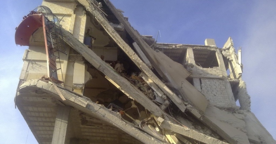 28.out.2012 - Prédio é destruído após caça das forças leais ao ditador Bashar al-Saad disparar mísseis na cidade de Erbeen, na Síria