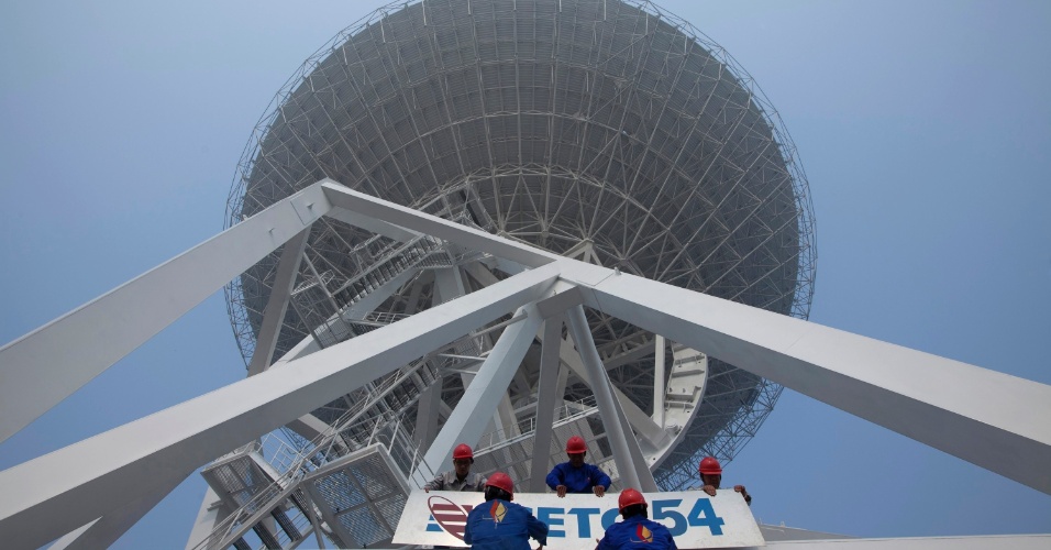 29.out.2012 - Funcionários fixam placas de companhia de tecnologia na base do radiotelescópio recém-construído em Xangai, na China, no último domingo (28). O instrumento de observação espacial tem cerca de 70 metros de altura e pesa mais de 2,65 toneladas