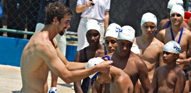 Michael Phelps distribuiu medalhas durante sua visita ao Rio de Janeiro, nesta terça
