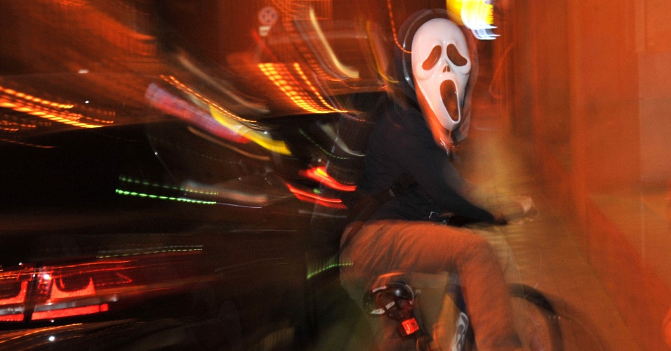 01.nov.2012 - Jovem vestindo uma fantasia de Halloween em sua bicicleta na Yerevan, na Armênia