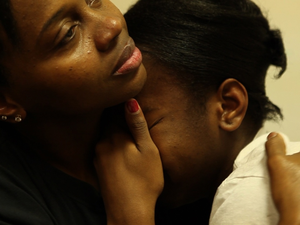 A jovem Ja'Meya é consolada pela mãe. O filme revela como a aluna exemplar foi levada a sacar uma arma engatilhada dentro de um ônibus escolar por conta da perseguição dos colegas - Divulgação