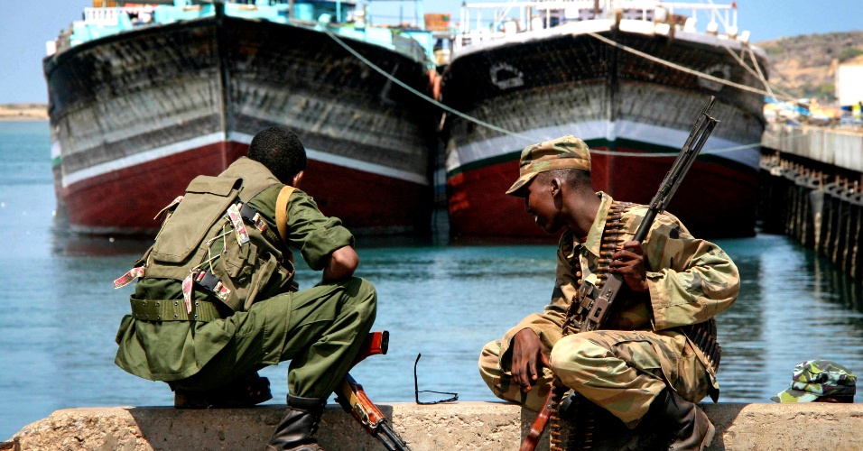 3.nov.2012 - Soldados do Exército Nacional Somaliano e da brigada governista Ras Kamboni observam barcos ancorados no porto de Kismayo, no sul do país