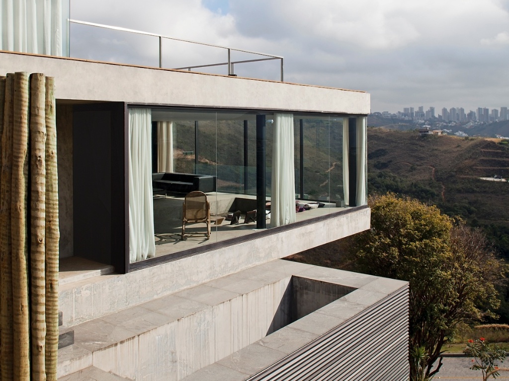 Vista de uma das laterais da casa EG, em Nova Lima (MG), com projeto do escritório Play Arquitetura. Encravada na serra, em um terreno íngreme, a construção foi fundada através de tubulões e cortinas de concreto - Leonardo Finotti/ UOL