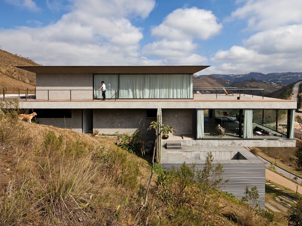 A casa EG, projetada pelo arquiteto Marcelo Alvarenga - em Nova Lima (MG) -, tem uma disposição pouco comum. No piso ao rés do chão, a porção íntima - especialmente os quartos - fica próxima à garagem, no bloco intermediário estão os ambientes de uso comum, a piscina e um terraço, enquanto o pavimento mais elevado abriga uma sala íntima e o escritório que dá acesso a um amplo deck - Leonardo Finotti/ UOL