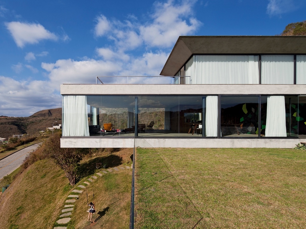 Estruturada em balanço, a casa EG - em Nova Lima (MG) - cria contrastes entre a dureza e a ludicidade ou as linhas retas e a sinuosidade da serra, entre atrair o olhar e preservar a privacidade. Parte dessa dualidade está na forma como o projeto foi implantado no terreno, as orientações da fachada e a leveza conseguida pelo balanço das estruturas - Leonardo Finotti/ UOL