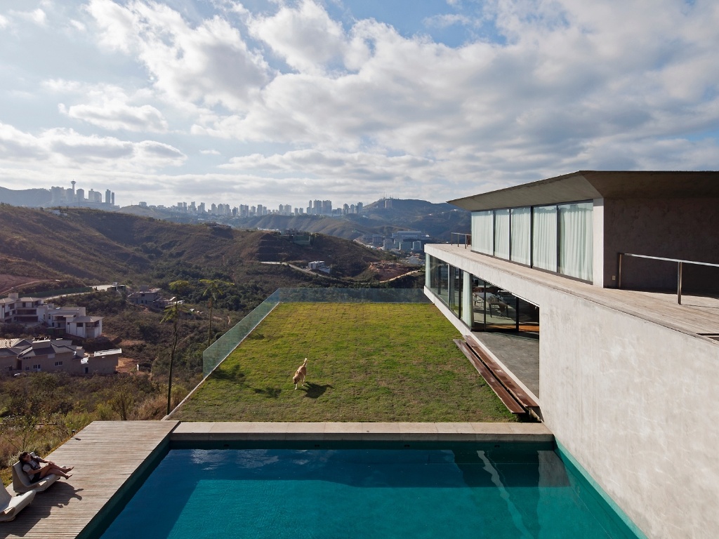 Sobre a laje de cobertura do bloco que reúne os quartos da casa EG, em Nova Lima (MG), está um pátio gramado que serve tanto à piscina quanto à ala social da residência. A grama ajuda, também, a manter a regularidade da temperatura interna dos dormitórios. O projeto é assinado pelo arquiteto Marcelo Alvarenga, do escritório Play - Leonardo Finotti/ UOL