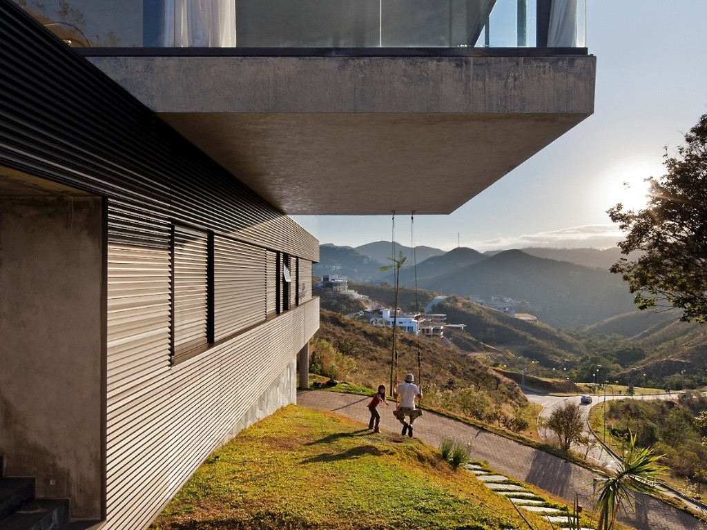 Um balanço de brinquedo foi instalado sob a laje do bloco social, em balanço construtivo, da casa EG. O projeto da residência em Nova Lima (MG) é assinado pelo arquiteto Marcelo Alvarenga. Lúdico, o recurso enfatiza a importância da paisagem para a constituição do desenho arquitetônico ali desenvolvido - Leonardo Finotti/ UOL
