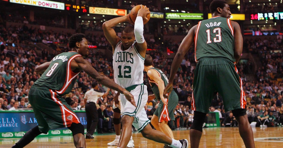 Leandrinho (c), do Boston Celtics, tenta passar pela marcação dos Bucks 