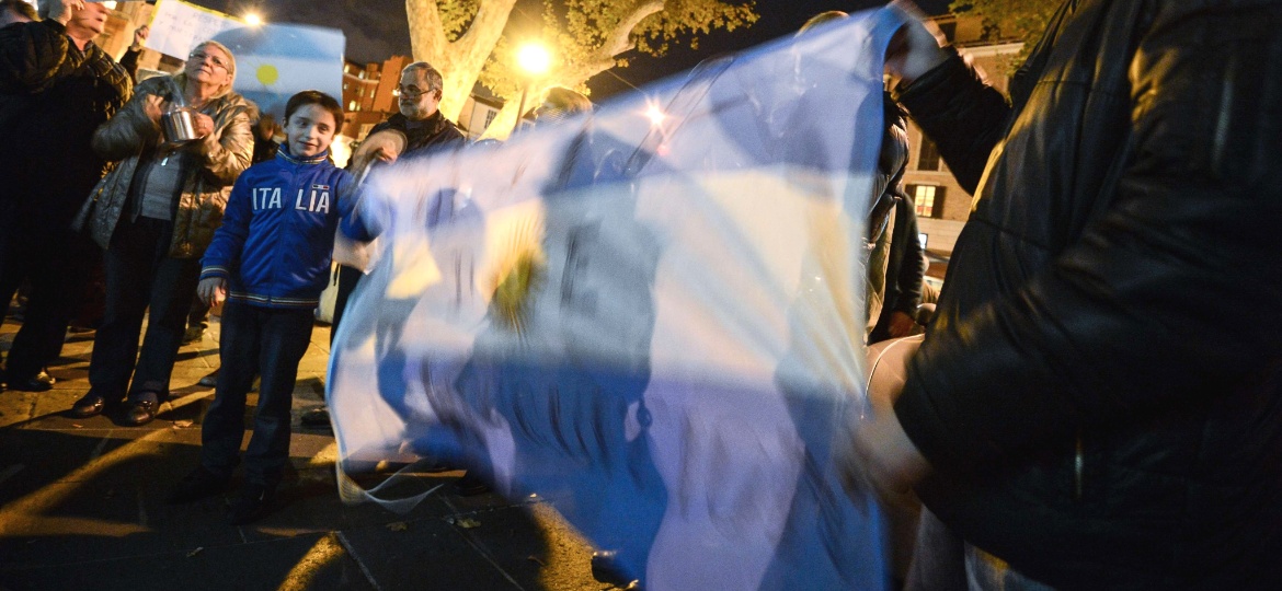 8.nov.2012 - Garoto ajuda a estender uma bandeira argentina durante protesto contra o governo de Cristina Kirchner e problemas como a crescente inflação - Andreas Solaro/AFP