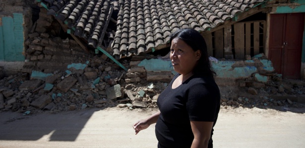 Mulher permanece em frente à casa em que morava e que foi destruída por um terremoto na Guatemala - Saúl Martínez/EFE
