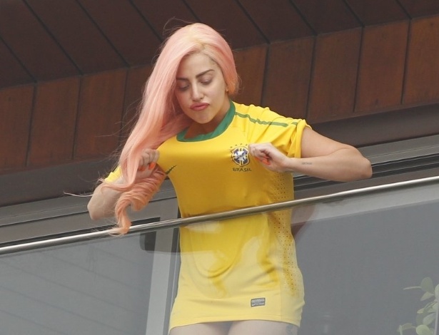 Vestida com uma camisa da seleção brasileira de futebol, a cantora Lady Gaga sai na sacada do hotel Fasano, no Rio de Janeiro para acenar para os fãs (8/11/12