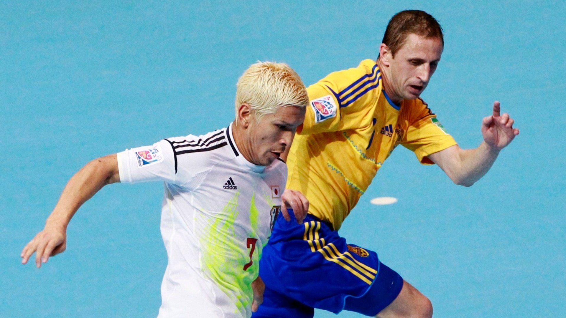 O japonês loiro Morioka se protege da marcação de um rival ucraniano nas oitavas da Copa do Mundo de futsal