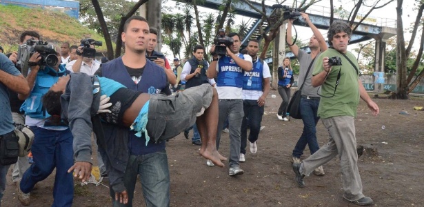 Funcionário da Assistência Social carrega uma suposta dependente de crack durante operação de combate à droga - Fabio Teixeira/AE
