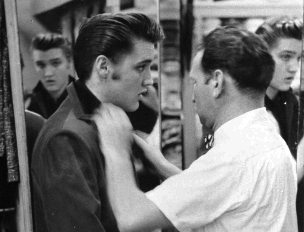 Em foto de 1956, Bernard Lansky faz os últimos ajustes em figurino de Elvis Presley - AP Photo