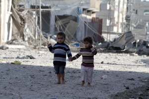 Crianças palestinas andam entre edifícios destruídos após ataques aéreos israelenses na Faixa de Gaza