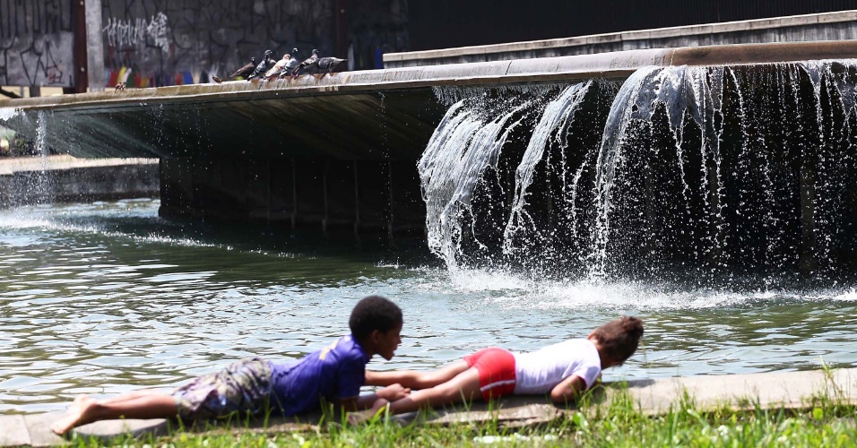 19.nov.2012 - Crianças brincam perto de fonte no centro de São Paulo no começo da tarde desta segunda-feira (19)