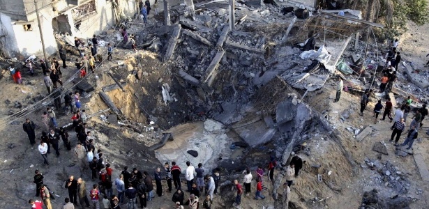 Pessoas observam casa destruída depois de ataque aéreo israelense em Khan Younis - Ibraheem Abu Mustafa/Reuters