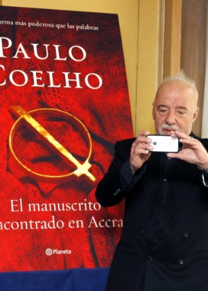 O escritor Paulo Coelho fotografa jornalistas com seu iPhone durante lançamento de "El Manuscrito Encontrado en Accra", na Espanha (21/11/12) - J.J. Guillén/EFE