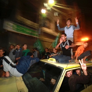 Palestinos saíram às ruas na noite desta quarta-feira (21) para comemorar o cessar-fogo de Israel em Gaza - Mohammed Salem/Reuters