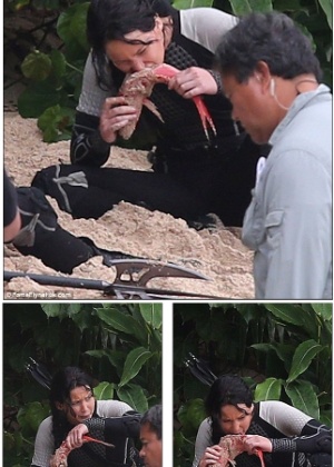 28.nov.2012 - Jennifer Lawrence come peixe cru em filmagens de sequência de "Jogos Vorazes"  - Reprodução/Daily Mail