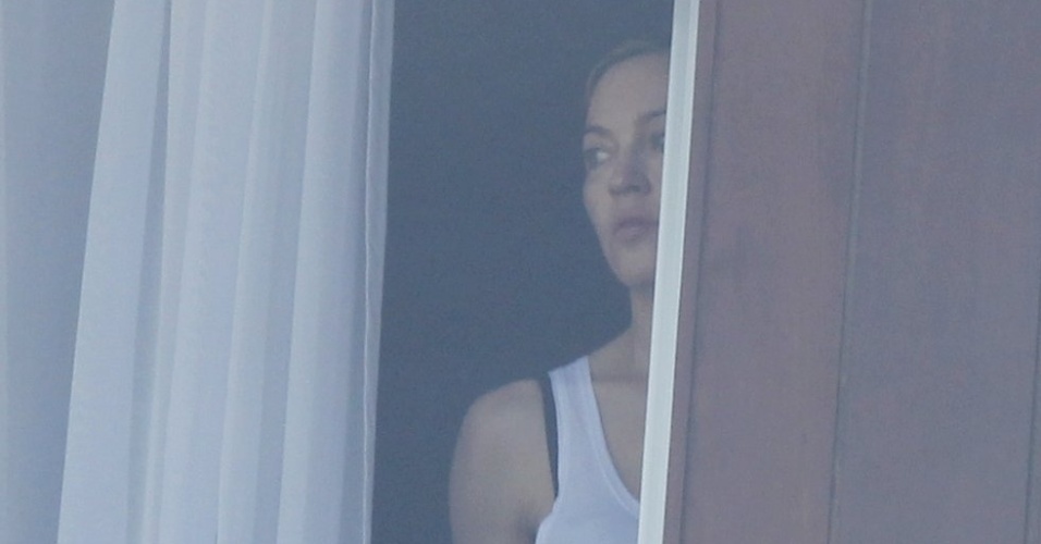 2.dez.2012: Por volta das 12h, Madonna dá o ar da graça, por trás da cortina de seu quarto no hotel Fasano