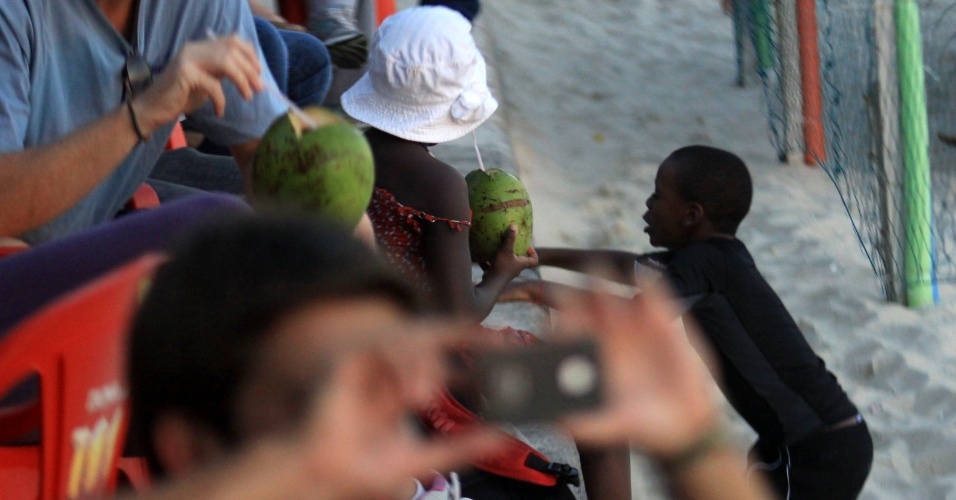 6.dez.2012 - David Banda e Mercy James, filhos de Madonna, aprendem a surfar e tomam água de coco na praia de Ipanema, no Rio de Janeiro