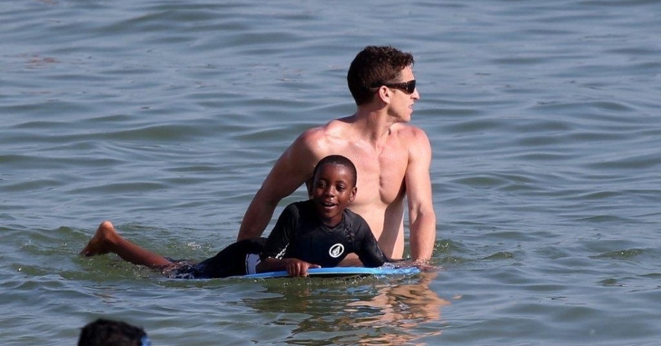 6.dez.2012 - David Banda e Mercy James, filhos de Madonna, aprendem a surfar e tomam água de coco na praia de Ipanema, no Rio de Janeiro