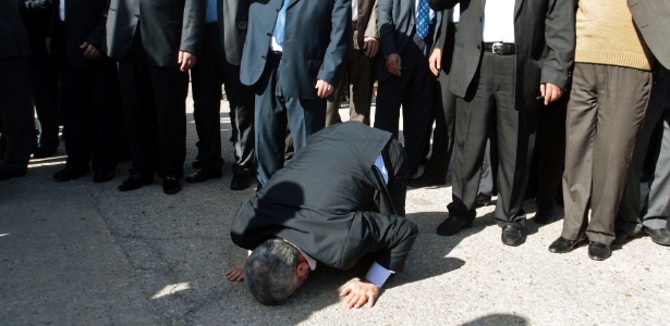 O líder do Hamas no exílio, Khaled Meshaal, beija o chão ao chegar na faixa de Gaza, nesta sexta-feira (7)