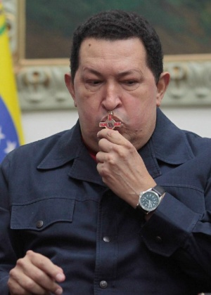 O presidente venezuelano, Hugo Chávez, beija crucifixo durante pronunciamento nacional<br>no Palácio de Miraflores, em Caracas