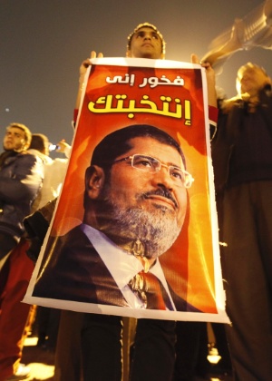 10.dez.2012 - Manifestante segura cartaz com o rosto do presidente do Egito, Mohamed Mursi, durante protesto pró-governo, no Cairo. A oposição do país rejeitou o plano de Mursi para realizar um referendo constitucional nesta semana - Amr Abdallah Dalsh/Reuters