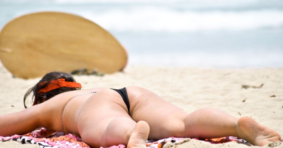 11.dez.2012 - Mulher toma sol na praia de Itamambuca, em Ubatuba, litoral norte de São Paulo, nesta terça-feira de muito calor