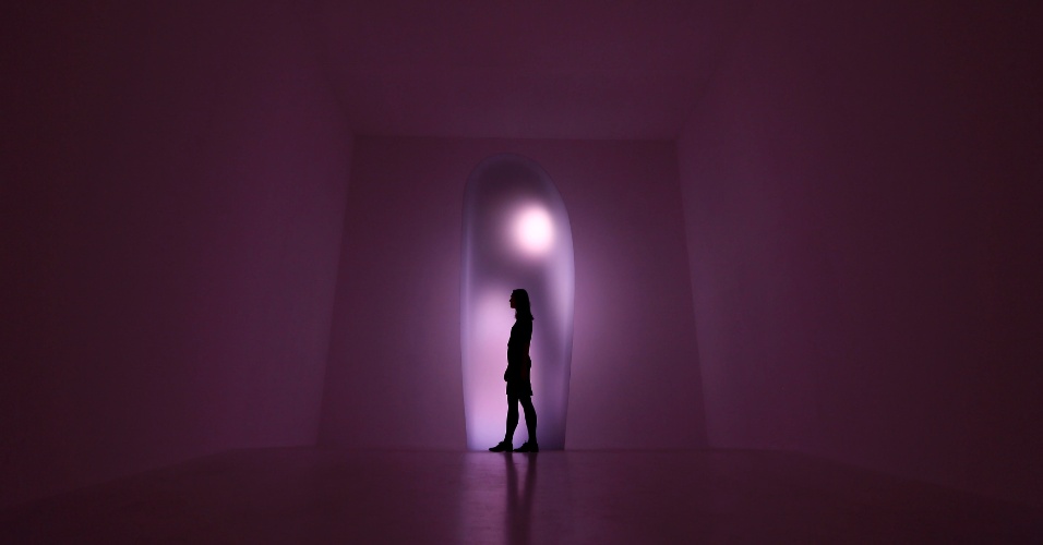 11.dez.2012 - Uma funcionária da galeria passa junto a obra "Tom Na H-iu" de vídeo e performance do artista japonês Mariko Mori na Royal Academy of Arts em Londres