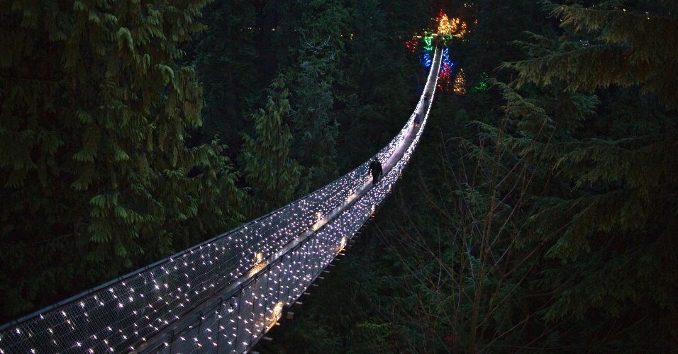 11.dez.2012 - Visitantes atravessam a Ponte Suspensa Capilano decorada com luzes de Natal em North Vancouver, no Canadá