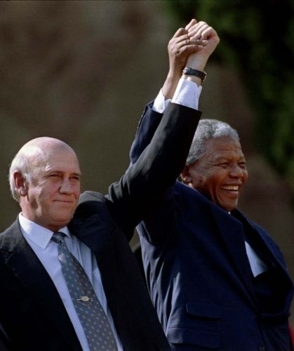 10.mai.1994 - Eleito presidente da África do Sul naquele ano, Nelson Mandela e o ex-presidente de Klerk, erguem os braços após inauguração de sindicato em Johannesburgo. Mandela venceu a primeira convocação de eleições democráticas multirraciais no país. A vitória pôs fim a três séculos e meio de dominação da minoria branca na África do Sul