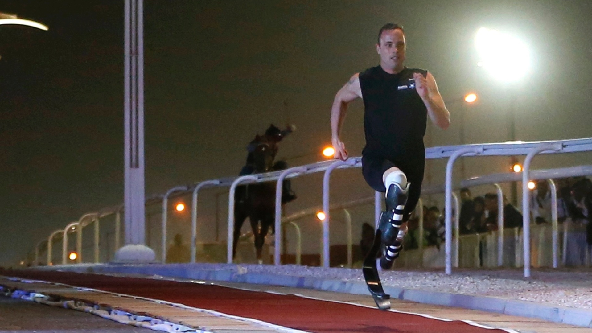 12.dez.2012 - Oscar Pistorius vence corrida de exibição contra cavalo puro-sangue no Qatar