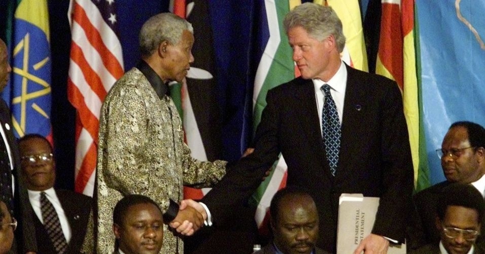 28.ago.2000 - Mandela cumprimenta o então presidente dos EUA, Bill Clinton, em encontro para promover negociações de paz para o Burundi, na Tanzânia