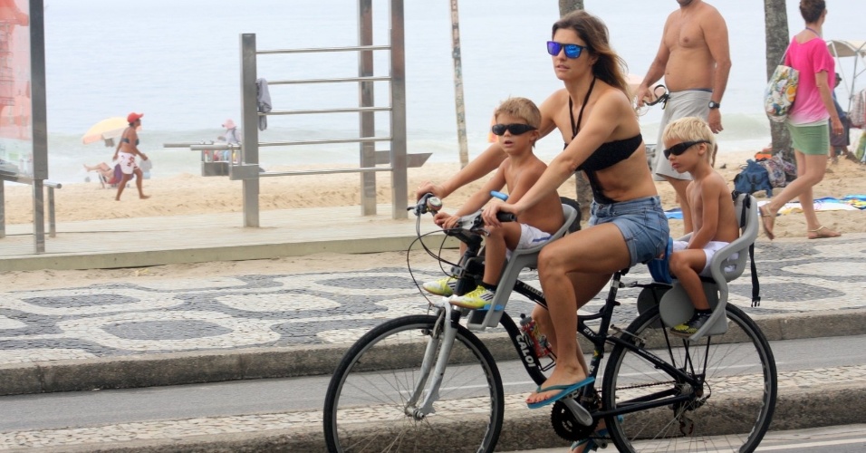 16.dez.2012 - Fernanda Lima passeou de bicicleta com os filhos, os gêmeos João e Francisco, pela orla da praia de Ipanema, zona sul do Rio