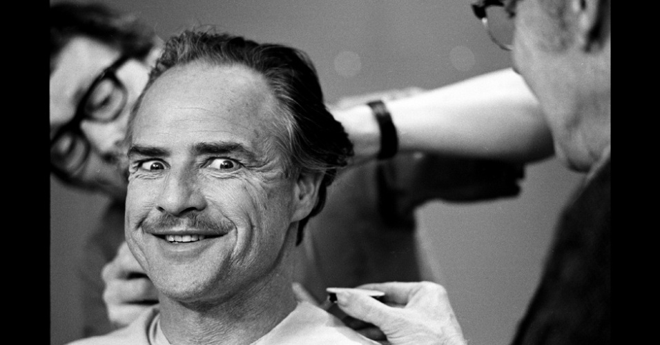 17.dez.2012 - O ator Marlon Brando sorri enquanto é maquiado nos bastidores do filme "O Poderoso Chefão" - Steve Shapiro/Now and Then
