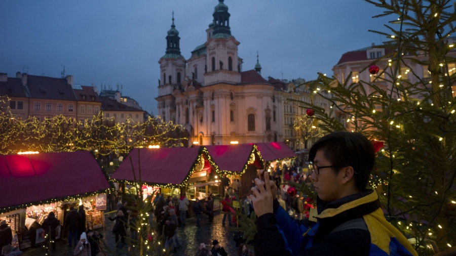 Em foto antes da pandemia, turista tira fotos do tradicional mercado de Natal em praça de Praga, na República Tcheca - Michal Cizek/AFP Photo