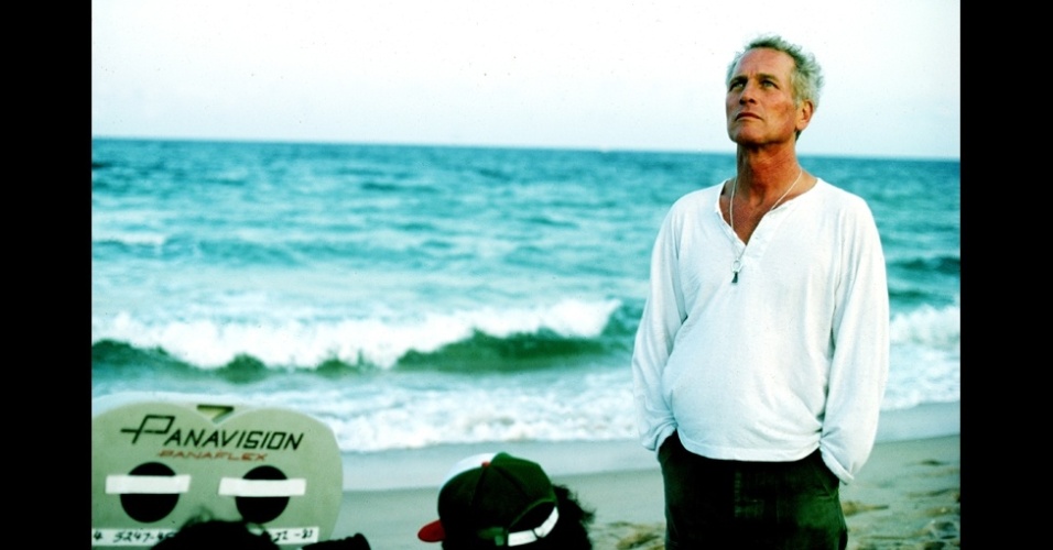 O ator Paul Newman é fotografado em uma praia durante pausa em um set de filmagem.  A imagem faz parte do livro "Now and Then" - Steve Shapiro/Now and Then