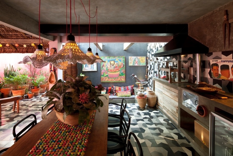 A mistura de cores, texturas e referências - tão caras ao trabalho de Marcelo Rosenbaum - fica em evidência da área da churrasqueira da Casa do Arquiteto. No ambiente amplo cabem as luminárias de crochê, da Bertolucci, os ladrilhos "Bandeirinha" (Brasil Imperial), madeiras de demolição e elementos coloridos e bem brasileiros feitos de fibra - Leonardo Finotti/ UOL