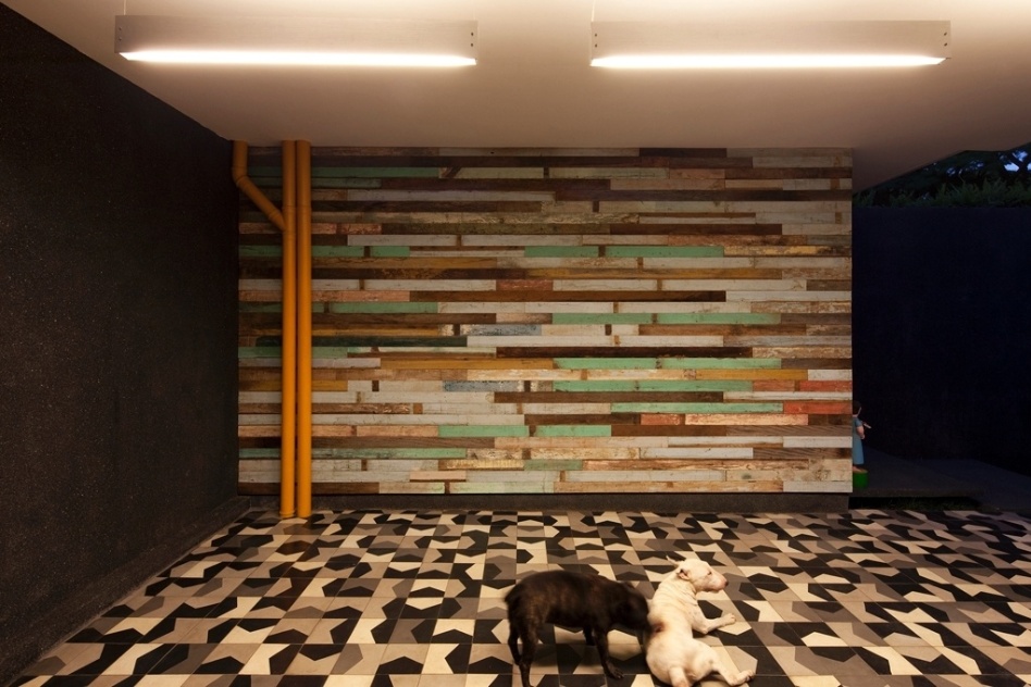 Na garagem da Casa do Arquiteto, com projeto de reforma assinado por Marcelo Rosenbaum, a parede revestida com madeiras de demolição ganha em cor. No chão, destaque para o ladrilho hidráulico Bandeirinha, desenhado por Rosenbaum e produzido pela Brasil Imperial - Leonardo Finotti/ UOL