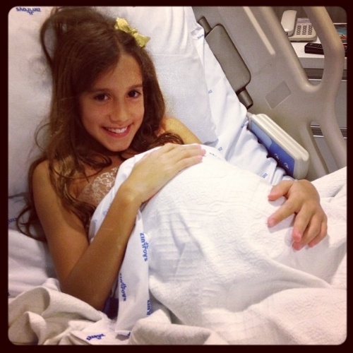 21.Dez.2012 - Clara, 7, filha de Rodrigo Faro e Vera Viel, brinca de "grávida" na maternidade antes do nascimento da irmã, Helena