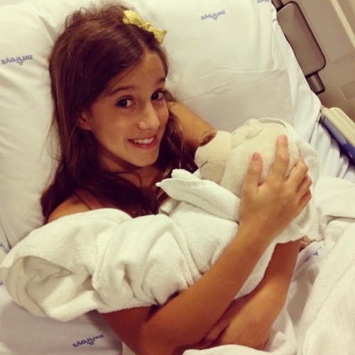 21.Dez.2012 - Clara, 7, filha de Rodrigo Faro e Vera Viel, posa com ursinho na maternidade antes do nascimento da irmã, Helena