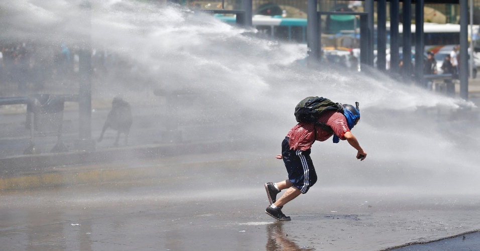 21.dez.2012 - Estudante é atingido por jato d'água durante protesto no Chile; manifestação não teria sido autorizada pelo governo