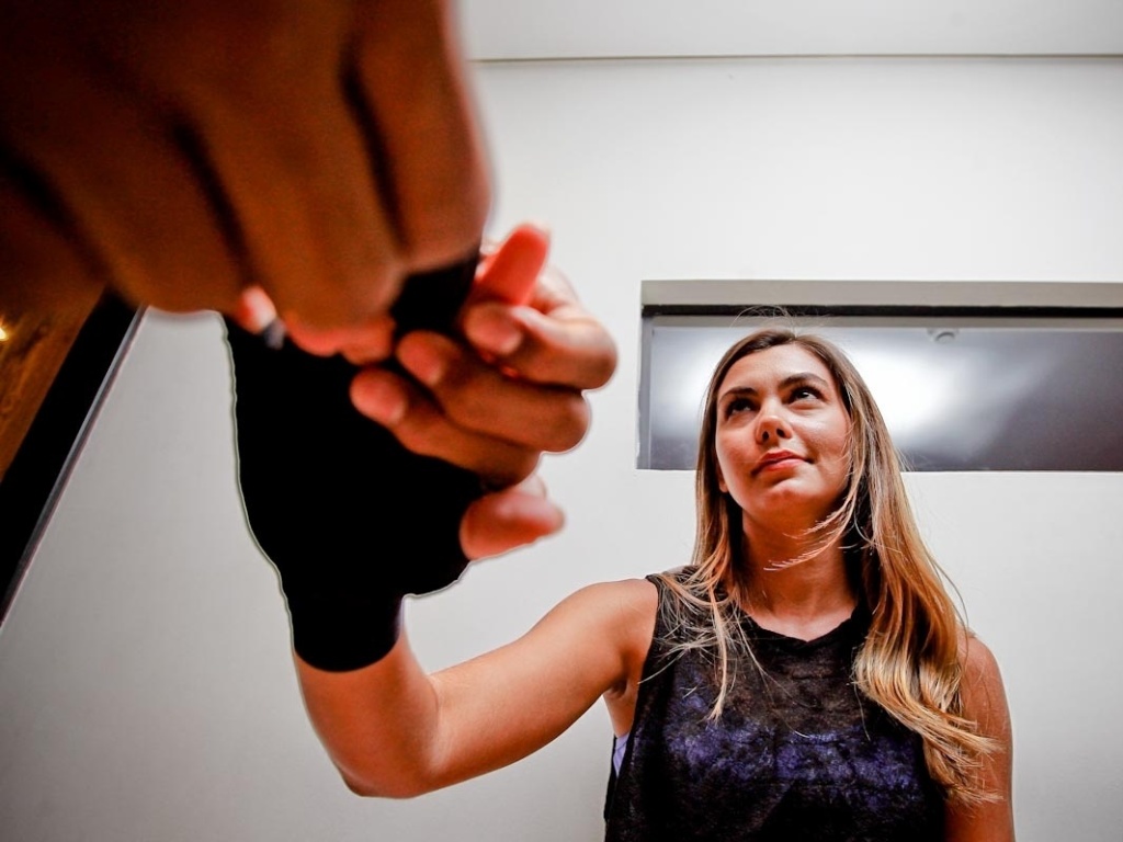 22.dez.2012- Lutador Tiago Alves enfaixa as mãos de Letícia Weirmann antes de iniciar os treinos - Leandro Moraes/UOL