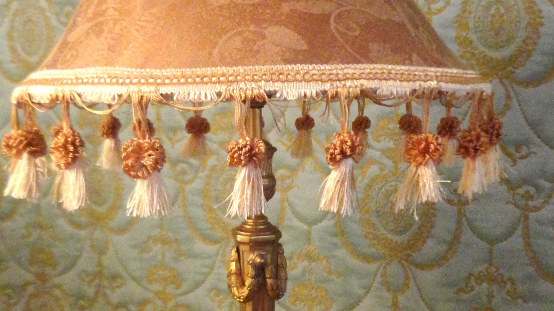 Na cúpula do abajur com base de metal e folhado à ouro da Began Antiguidades (www.began.com.br) tem aplicações de passamanes (estes pequenos cordões com franjinhas). Este tipo de acessório serve também para adornar cortinas, barrados de sofás e almofadas - Divulgação