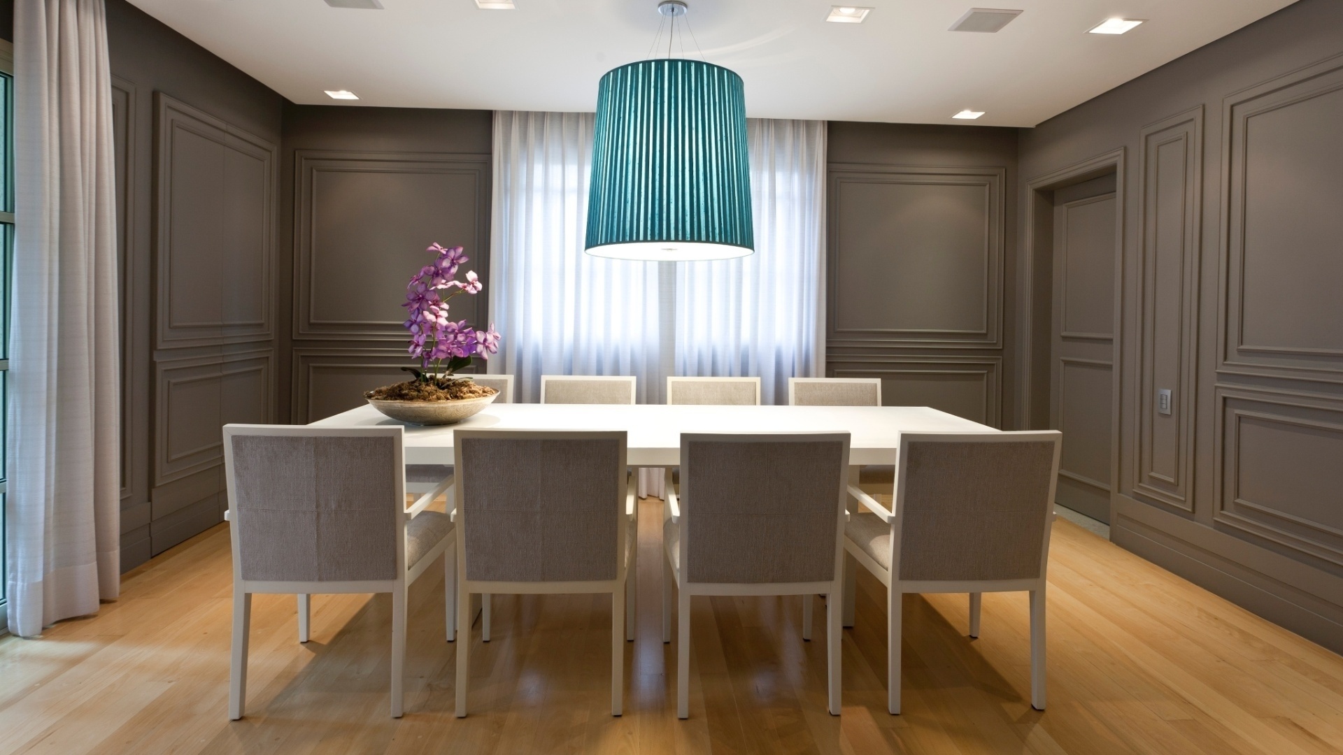 Na sala social de jantar do apartamento neoclássico decorado por Maurício Karam, todas as paredes receberam molduras de polipropileno (as chamadas boiseries), em tom único cinza escuro - Sergio Israel/ Divulgação