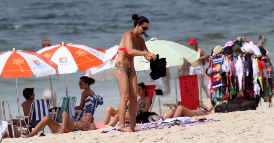 22.dez.2012 - Luíza Brunet se veste após aproveitar a praia de Ipanema, no Rio