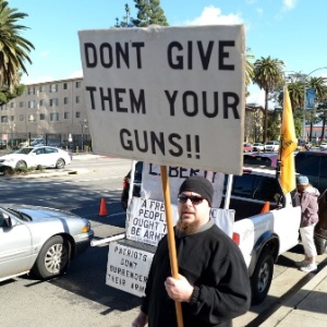 Manifestante protesta contra programa de devolução de armas organizado em Los Angeles (EUA)